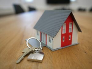 miniature de maison en bois blanche et rouge sur table marron