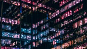 photographie architecturale d'un bâtiment avec des personnes à l'intérieur pendant la nuit