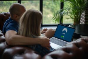 homme et femme assis sur une chaise devant un MacBook Pro