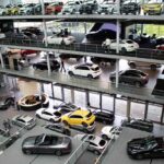 Showroom automobile avec plusieurs voitures neuves exposées sur plusieurs étages vitrés