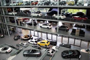 Showroom automobile avec plusieurs voitures neuves exposées sur plusieurs étages vitrés