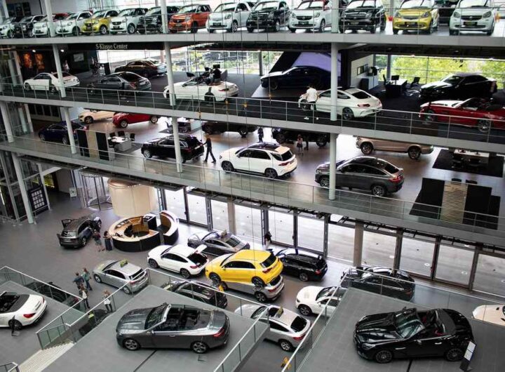 Showroom automobile avec plusieurs voitures neuves exposées sur plusieurs étages vitrés