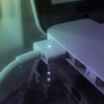 Ordinateur portable avec câble USB branché, lumières bleues clignotantes