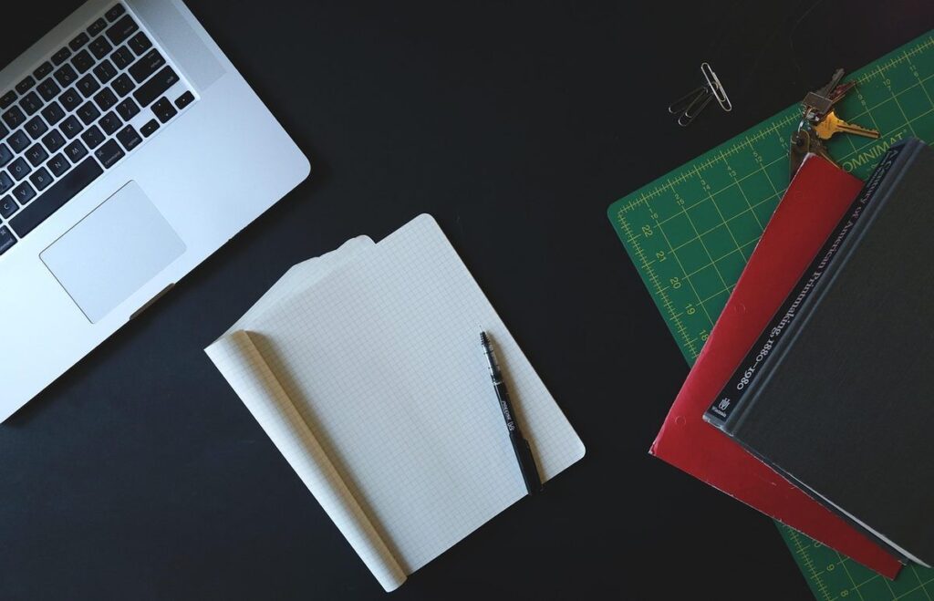 Espace de travail avec ordinateur portable, papier blanc, stylo et règle de dessin sur fond noir