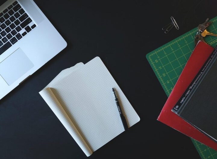 Espace de travail avec ordinateur portable, papier blanc, stylo et règle de dessin sur fond noir