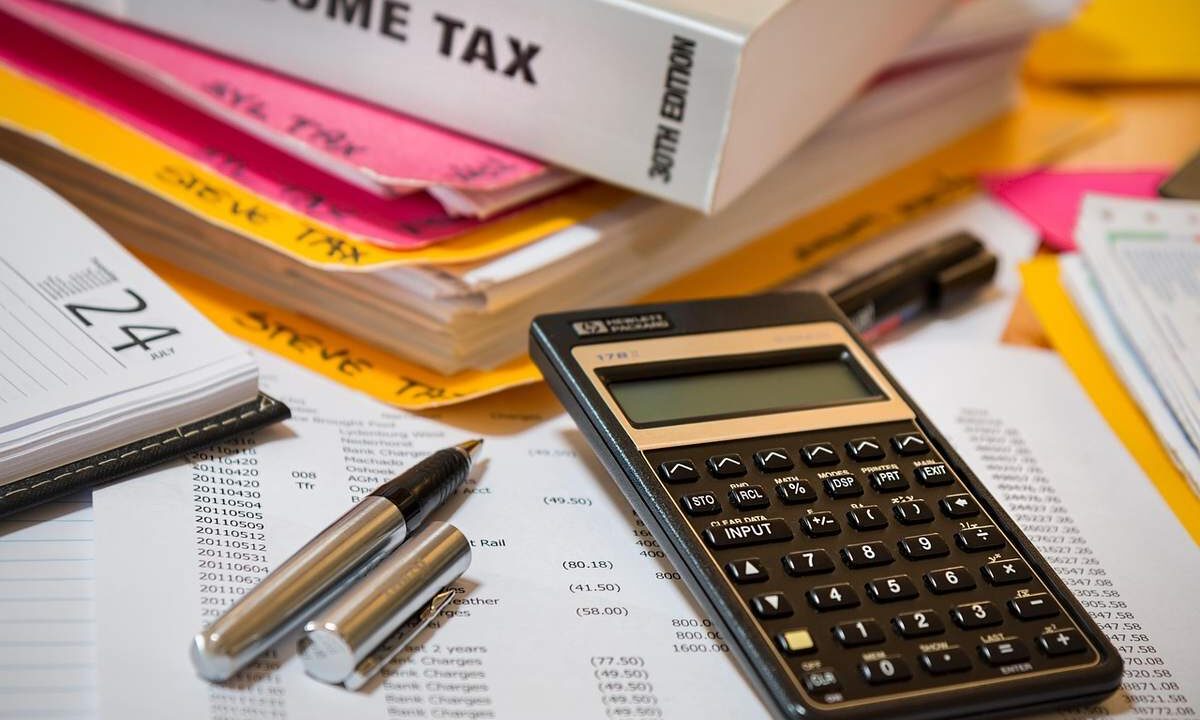Calculatrice, stylos, documents et livres sur un bureau de travail