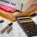Calculatrice, stylos, documents et livres sur un bureau de travail