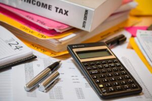 Calculatrice, stylos, documents et livres sur un bureau de travail