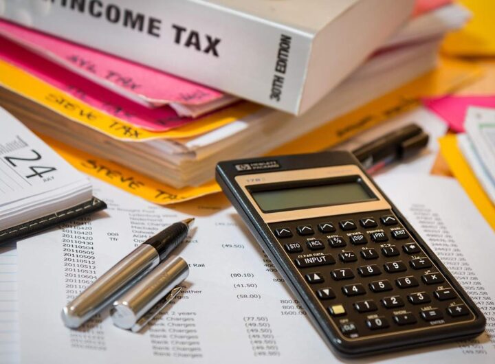 Calculatrice, stylos, documents et livres sur un bureau de travail