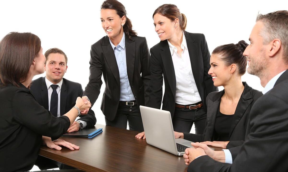 Six professionnels réunis autour d'une table avec ordinateur portable