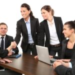 Six professionnels réunis autour d'une table avec ordinateur portable