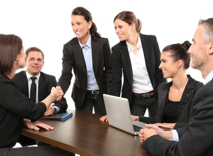 Six professionnels réunis autour d'une table avec ordinateur portable